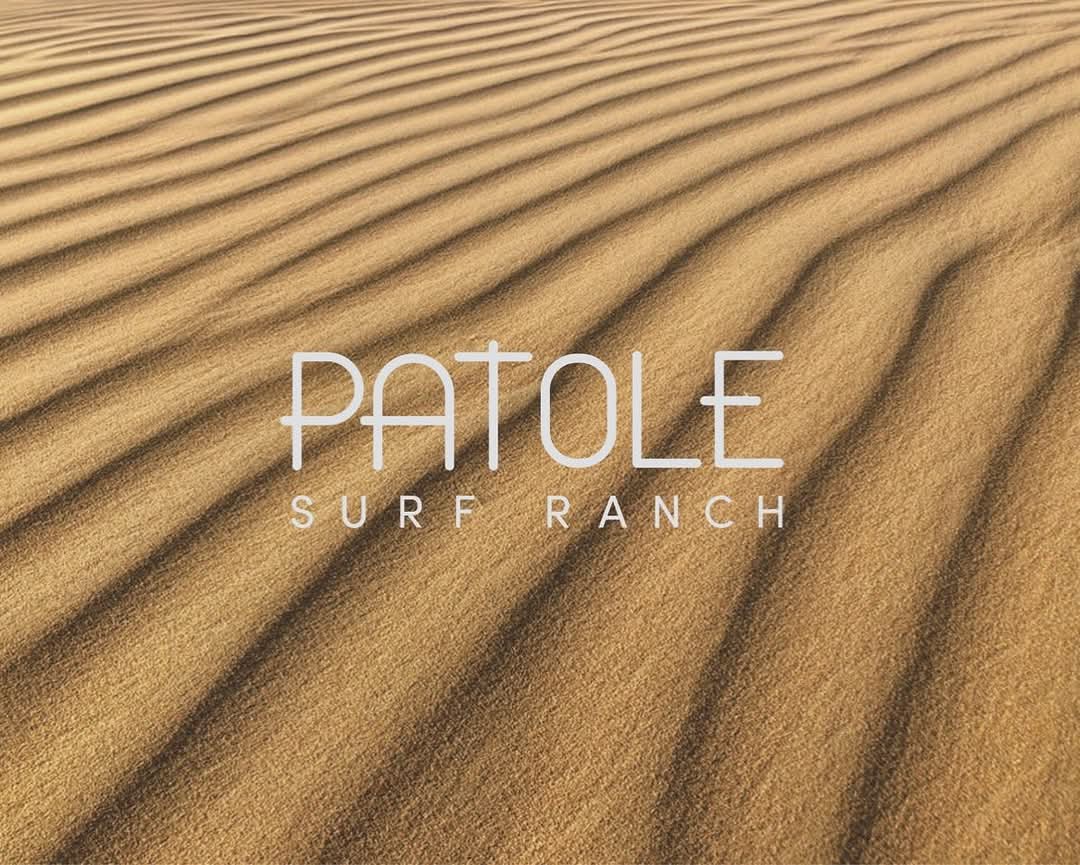 Arena rizada por el viento con el logotipo de Patole Surf Ranch