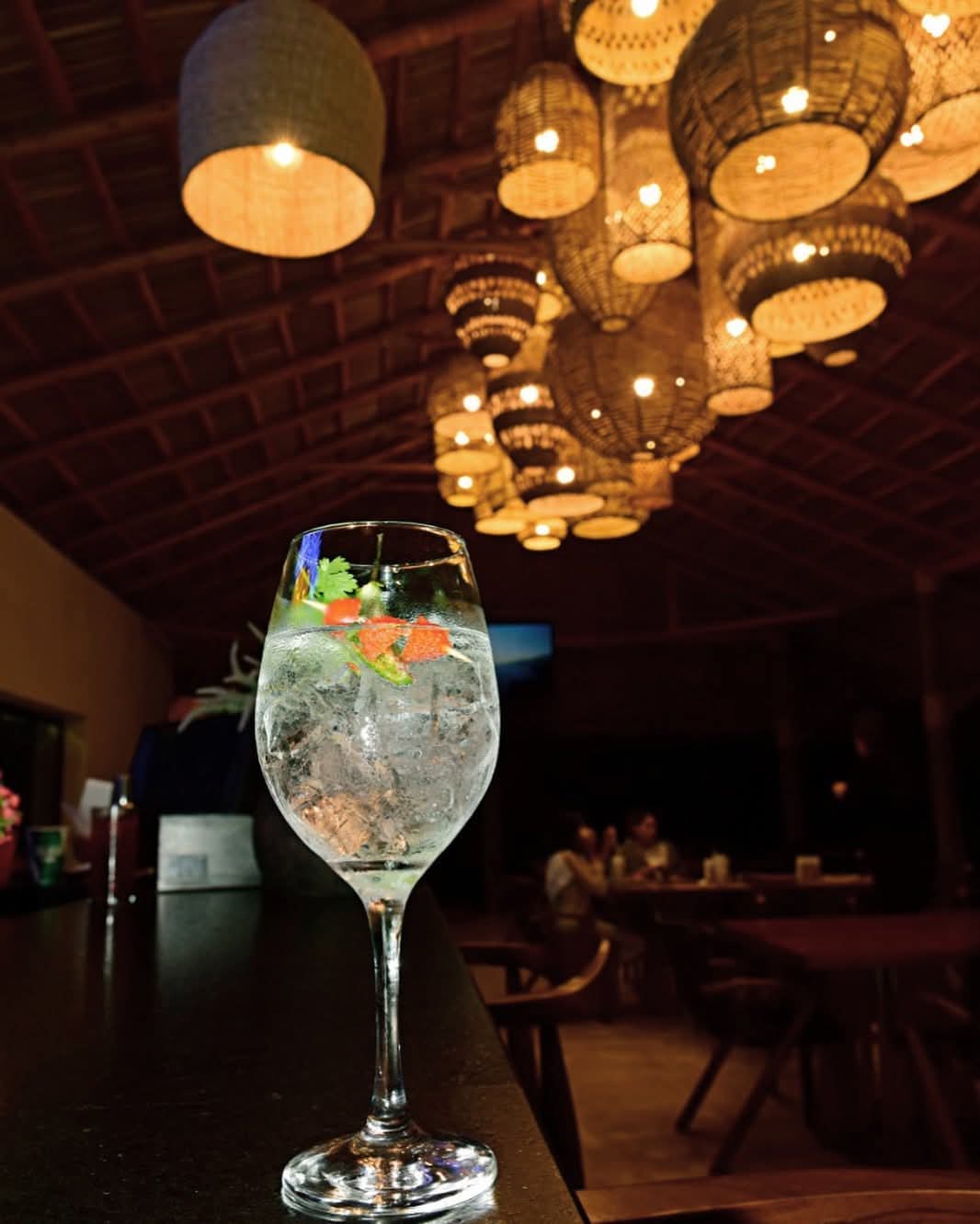 Barra de noche bajo el techo de palapa, con lámparas de mimbre encendidas